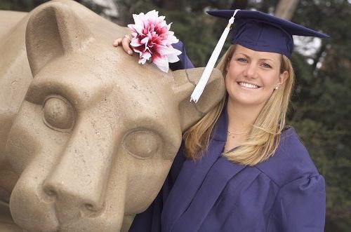即将毕业的女学生站在狮子神殿前，头戴礼帽，身穿长袍，靠在狮子身上
